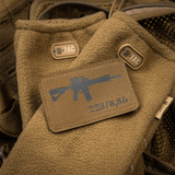 M-Tac AR-15 223/5,56 Laser Cut Patch fastgjort på brun taktik tæppe med M-Tac logoer, designet til udendørs og militærbrug.