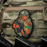 Alt tag: M-Tac Patch Tiger Green Tape PVC - 3D patch af tiger med AR-15, hjelm og QRS plate carrier på camouflageret udstyr.