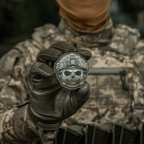 "M-Tac Patch Emoji #4" PVC med 3D-effekt, sjov morale patch med Velcro, perfekt til tøj eller udstyr, 6.5x6.5 cm, holdt af en soldat.