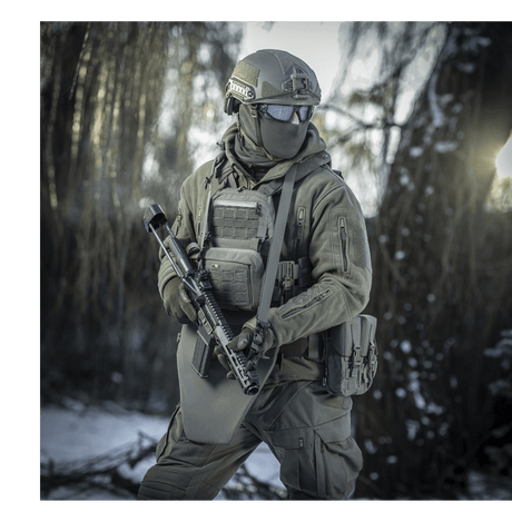 Soldat i vintermiljø med M-Tac Universal Våbenrem og taktisk udstyr til komfortabel geværhåndtering.