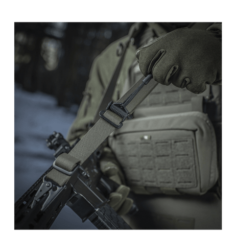 M-Tac Universal Våbenrem monteret på et gevær i brug, der viser det multifunktionelle design og komfort i vintermiljø.