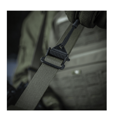 M-Tac Universal Våbenrem fastgjort til taktisk vest for komfortabel våbenhåndtering.