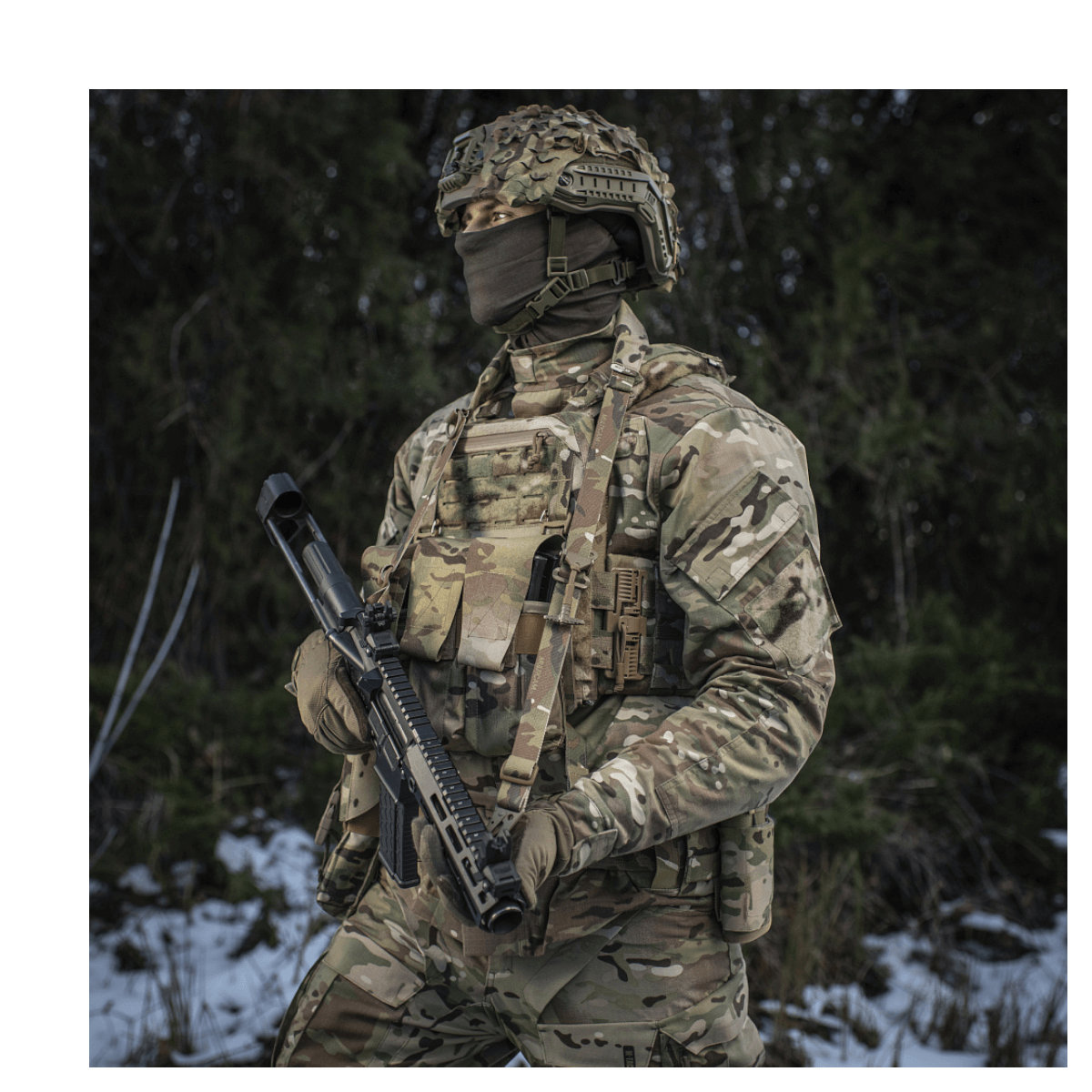 Soldat i camouflageuniform bærer M-Tac Universal Våbenrem i skovmiljø.