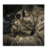 En soldat i camouflageudstyr bruger M-Tac Universal Våbenrem til et våben i et taktisk miljø.