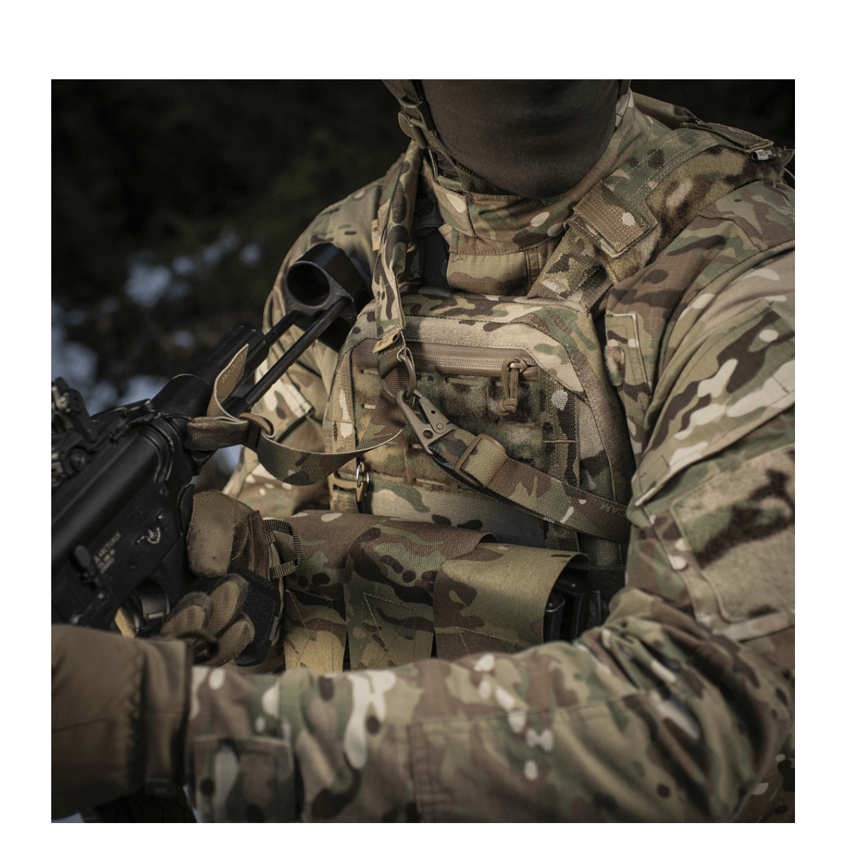 En soldat i camouflageudstyr bruger M-Tac Universal Våbenrem til et våben i et taktisk miljø.
