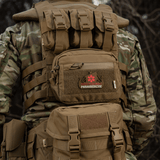 Taktisk rygsæk med 'Paramedicine' patch i camouflagemønster set bagfra i naturen, robust og holdbar til udendørs brug