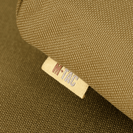 M-Tac Siddeunderlag med bæltebeslag ARMOR i Cordura 1000D, nærbillede af mærket, ideel til beskyttelse mod kulde og fugt.