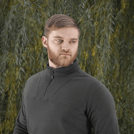 Mand iført M-Tac Delta Polartec Fleecejakke foran en grøn baggrund