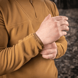 Nærbillede af en person iført en M-Tac Delta Polartec Fleecejakke i skoven, fremhæver jakkenes bløde og åndbare materiale.