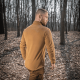 Mand iført M-Tac Delta Polartec Fleecejakke i skov, set bagfra, viser stil og funktionalitet i naturligt miljø.
