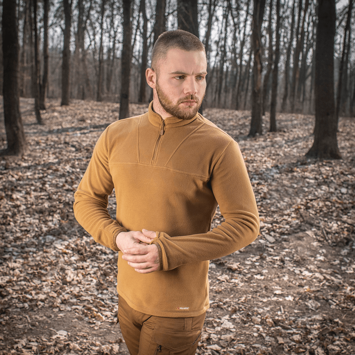 Mand iført M-Tac Delta Polartec Fleecejakke i skov, varm og åndbar jakke ideel til kolde dage med halv lynlås design.