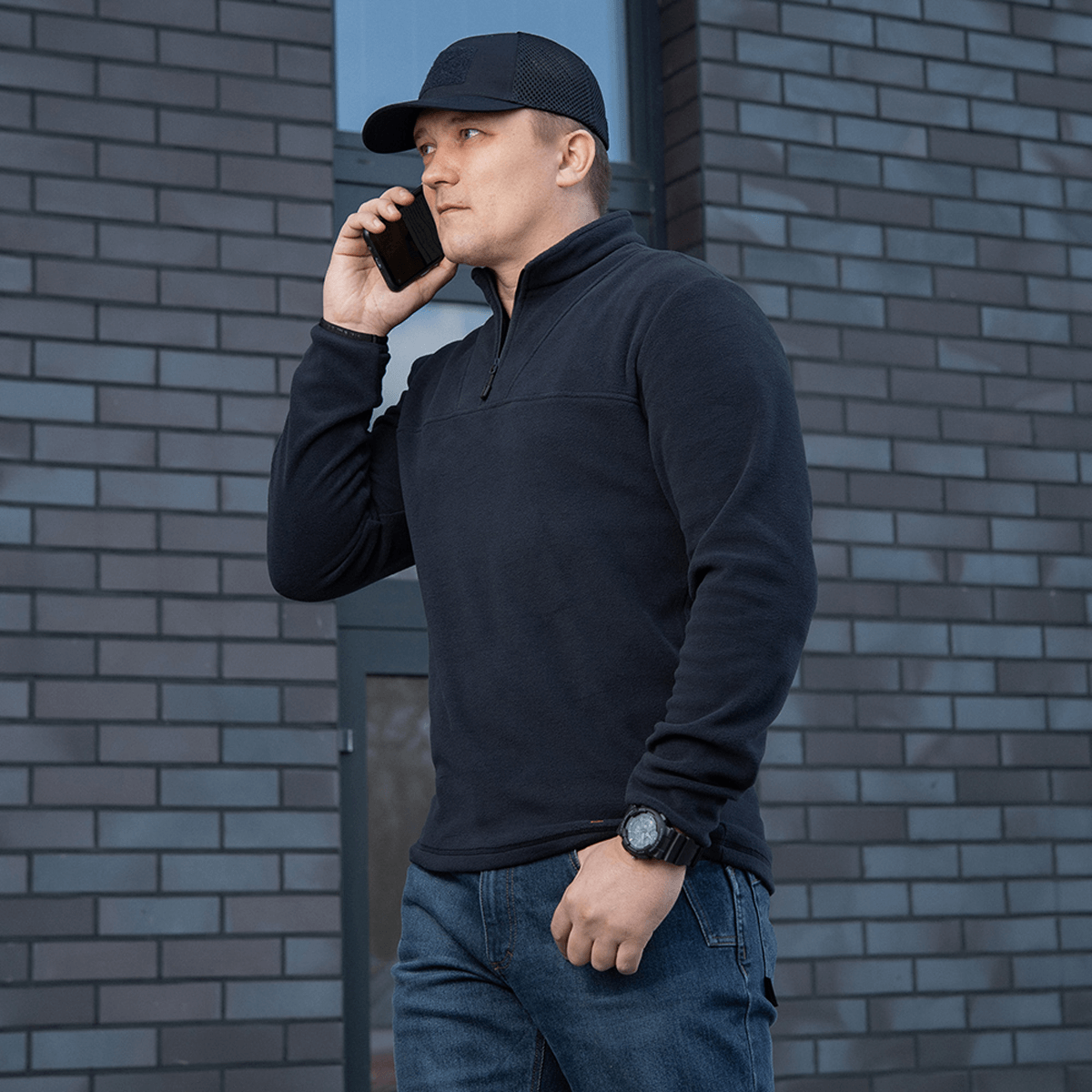 M-Tac Delta Polartec Fleecejakke i sort bæres af mand, stilren og funktionel, ideel til kolde dage, halv lynlås for nem på- og aftagning.