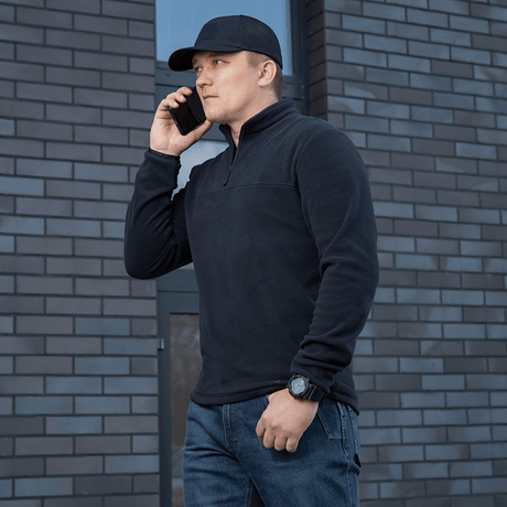 M-Tac Delta Polartec Fleecejakke i sort bæres af mand, stilren og funktionel, ideel til kolde dage, halv lynlås for nem på- og aftagning.