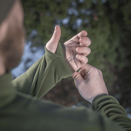 Mand iført M-Tac Delta Polartec Fleecejakke justerer manchet i naturen