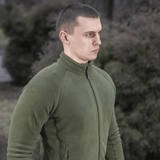 M-Tac Polartec Sport Fleecejakke i en grøn nuance, ideel til både overgangsperioder og som mellemlag i koldt vejr, bæres udendørs.