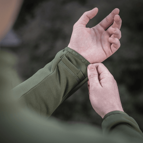 Nærbillede af en person iført M-Tac Polartec Sport Fleecejakke, der viser jakke ærmets design og materialekvalitet.