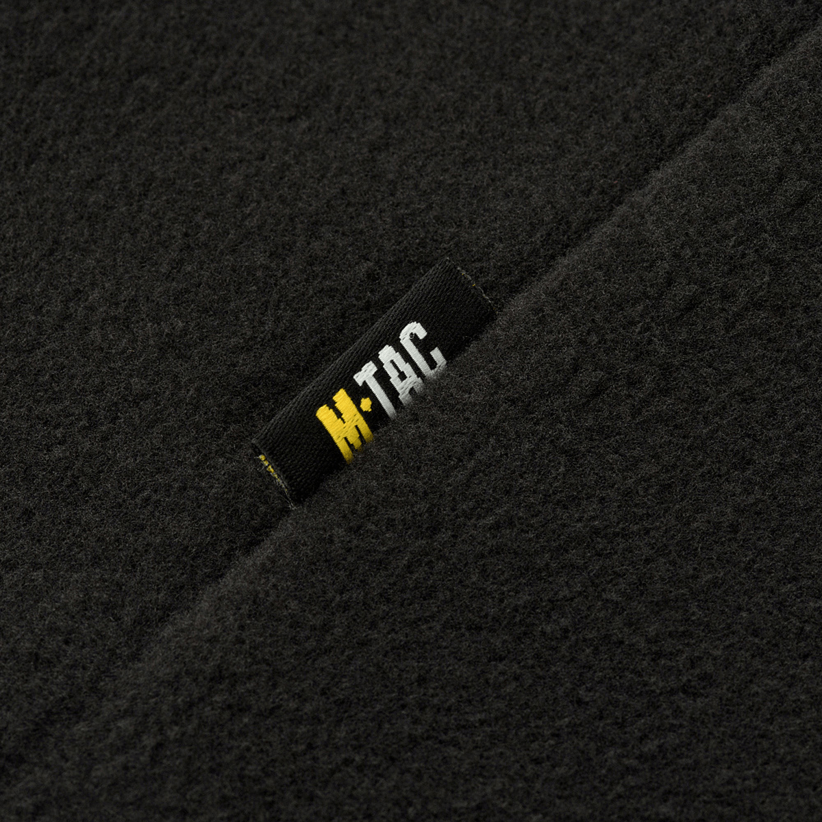 Nærbillede af M-Tac Delta Polartec Fleecejakke Dame med sort M-Tac logo på slidstærkt Polartec® Micro Series-fleece