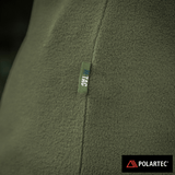 Nærbillede af M-Tac Delta Polartec Fleecejakke Dame i grøn med Polartec® logo, fremstillet af Polartec® Micro Series-fleece.