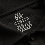 Størrelsesetiket på M-Tac Tactical Polo Shirt Langærmet 65/35 med 65% bomuld og 35% polyester, lavet i Ukraine.