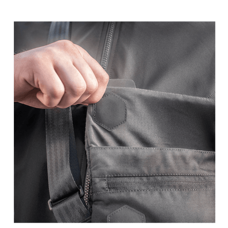 Hånd åbner lomme på M-Tac Konvert Taske Elite fremstillet af holdbart Cordura-materiale med magnetisk ventilåbning.