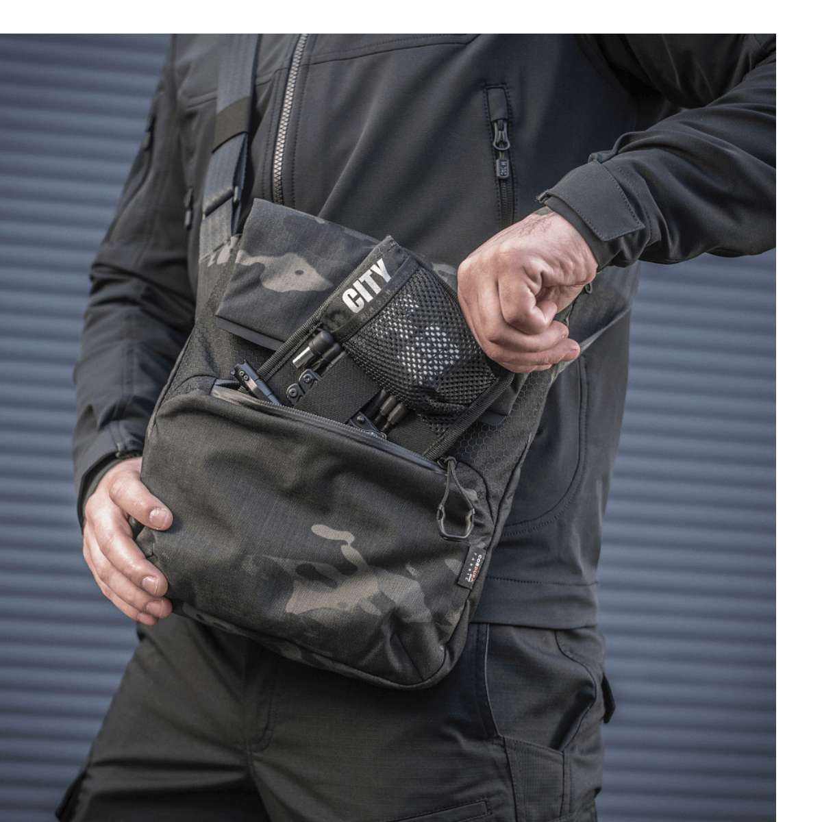 M-Tac Konvert Taske Elite i brug, lavet af slidstærkt Cordura materiale, med justerbar skulderrem og hurtig adgangs magnetventil.