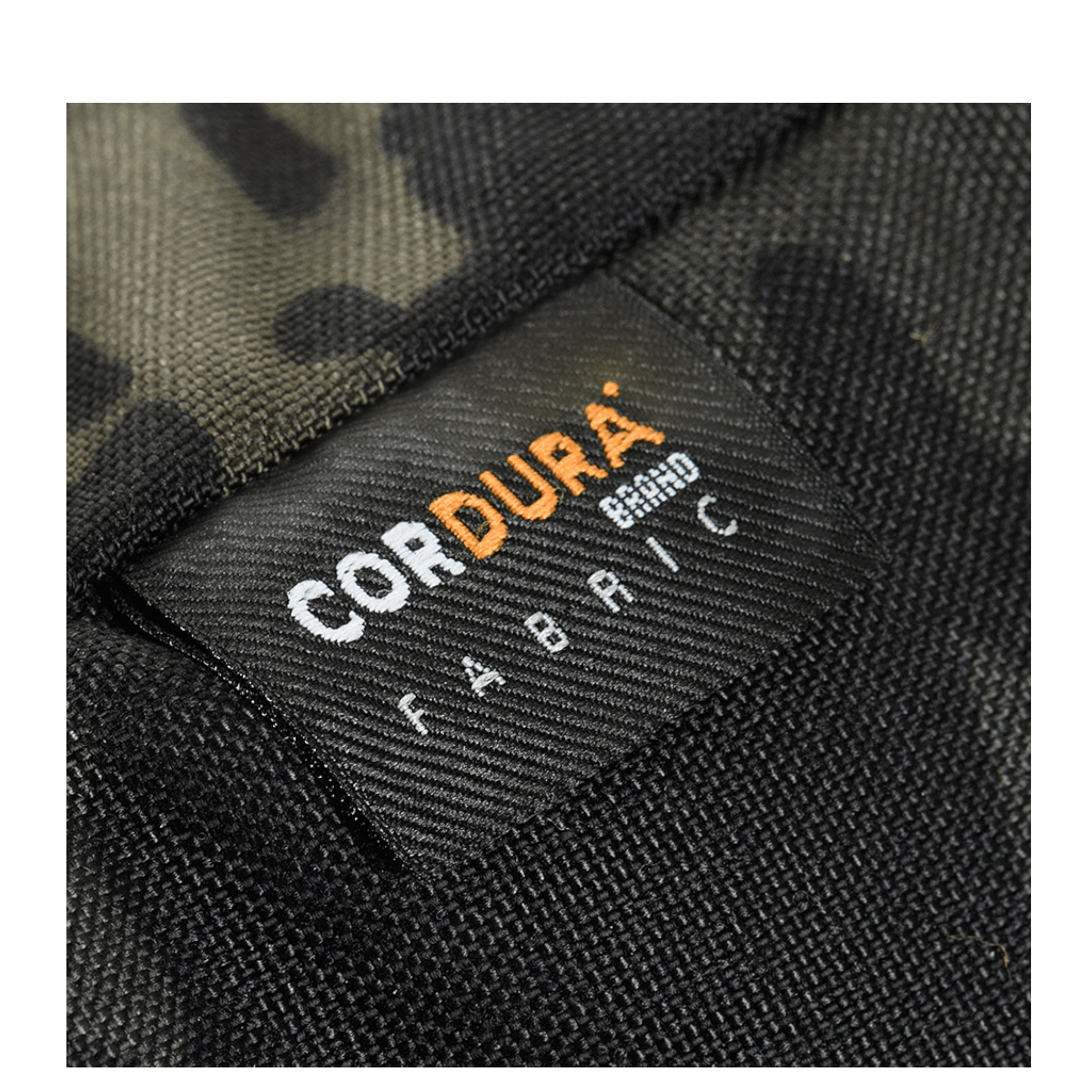 Nærbillede af M-Tac Konvert Taske Elite med Cordura 500D og Cordura Hex 1000D, der viser etiketten med materialemærkning.