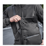 Mand med M-Tac Konvert Taske Elite i Cordura 500D, viser magnetventil for hurtig adgang. Tasken har justerbar skulderrem for komfort.