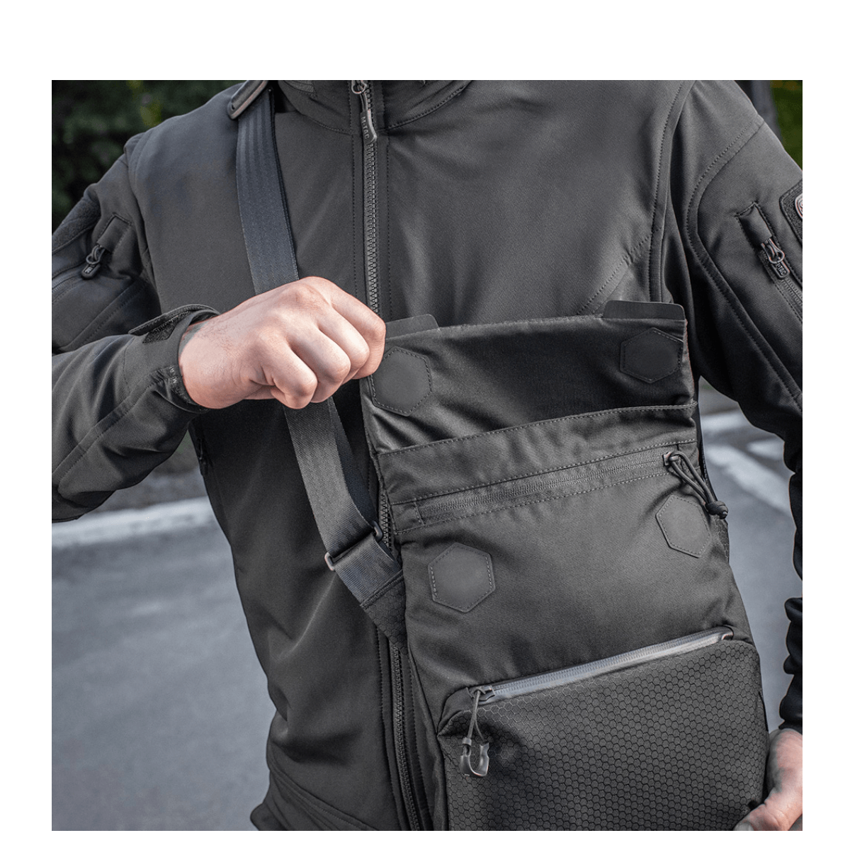 Mand med M-Tac Konvert Taske Elite i Cordura 500D, viser magnetventil for hurtig adgang. Tasken har justerbar skulderrem for komfort.