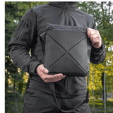 M-Tac Konvert Taske Elite i Cordura 500D og Hex 1000D, med tablet-design og justerbar skulderrem, holdt af person i naturen.