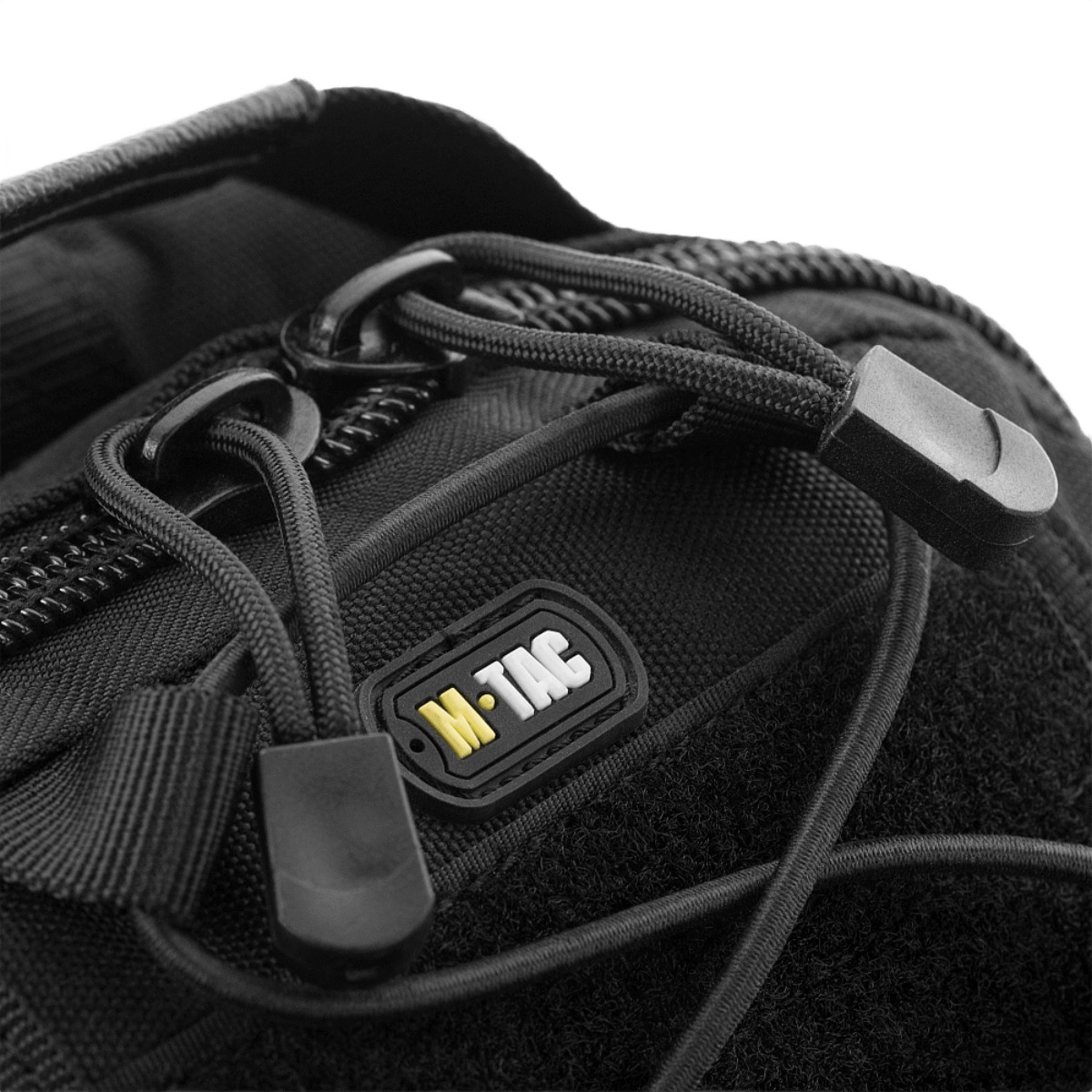 Nærbillede af lynlås og logo på M-Tac Urban Line City Patrol Fastex Taske, en vandafvisende og slidstærk taske.