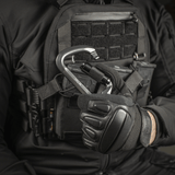 M-Tac Key-Lock Karabinhage af aluminium, egnet til klatring og sikkerhed, holdt af en person i taktisk udstyr.