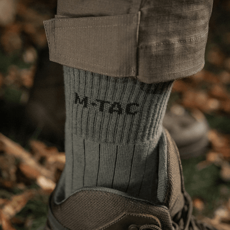 M-Tac Sokker Tactical Army på vandretur i skoven, designet til komfort og holdbarhed i naturen.