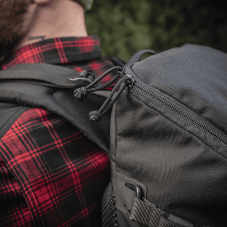 M-Tac Rygsæk Gen. II Elite – Small med lynlås og stropper set i brug mod en skovbaggrund.