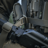 M-Tac Våbenbælte med Tre Punkter i brug til patruljering og konvojopgaver, designet til let våbenoverførsel mellem skuldre.