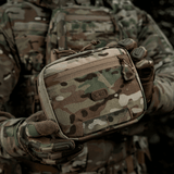 Taktisk M-Tac organizer pouch Elite fastgjort på rygsæk med M.O.L.L.E.-system, ideel til førstehjælpsudstyr og EDC-sæt.