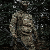 Taktisk soldat med M-Tac organizer pouch Elite fastgjort til vest via M.O.L.L.E.-systemet i skovklædt område.