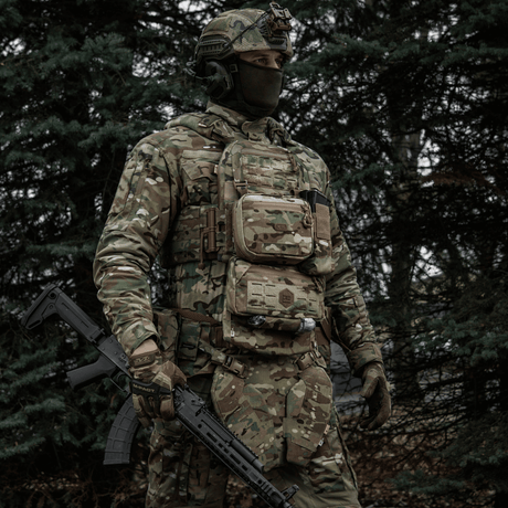 Taktisk soldat med M-Tac organizer pouch Elite fastgjort til vest via M.O.L.L.E.-systemet i skovklædt område.