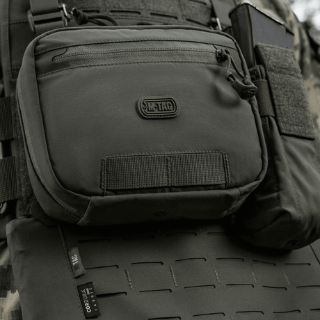 M-Tac organizer pouch Elite fastgjort til taktiske vest via M.O.L.L.E.-systemet, ideel til bæring af nødudstyr og EDC-sæt. Holdbar og praktisk.