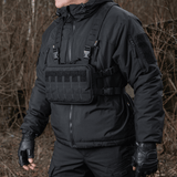 M-Tac Chest Rig Elite i brug, alsidig brysttaske med MOLLE panel og H-sele, ideel til taktisk brug og EDC, set udendørs.
