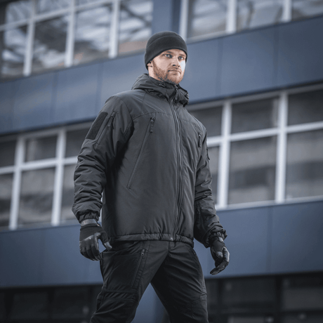 Mand iført M-Tac Alpha Gen.III Pro Vinterjakke i bymiljø, optimal til ekstreme forhold med komfort og vandafvisende materiale.