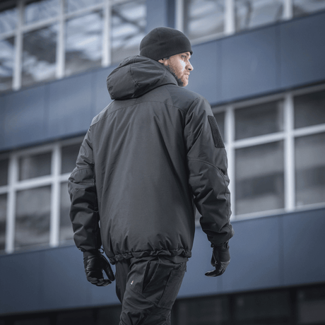 M-Tac Alpha Gen.III Pro Vinterjakke i sort, set bagfra på en mand i byen, designet til ekstrem kulde og regn, forbedret med G-Loft fyld.