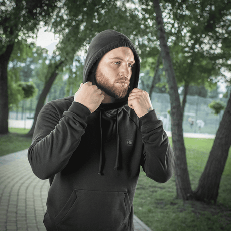 Mand i sort M-Tac Hættetrøje Cotton Raglan i park, klar til aktivitet