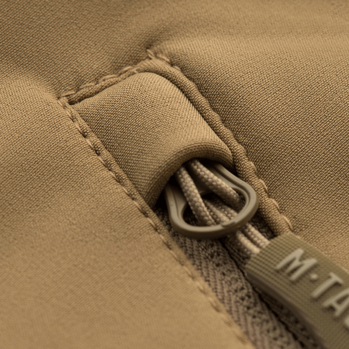 Nærbillede af lynlåsdetalje på M-Tac Soft Shell Jakke med Liner i beige farve