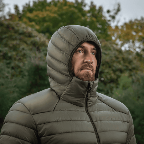 Mand iført M-Tac Stalker Gen. III Primaloft Jakke i naturen, viser jakken i brug og dens minimalistiske design.