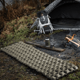 M-Tac Oppustelig Liggeunderlag 195x60 foran et telt på campingplads, klar til brug for komfort og varmeisolering.