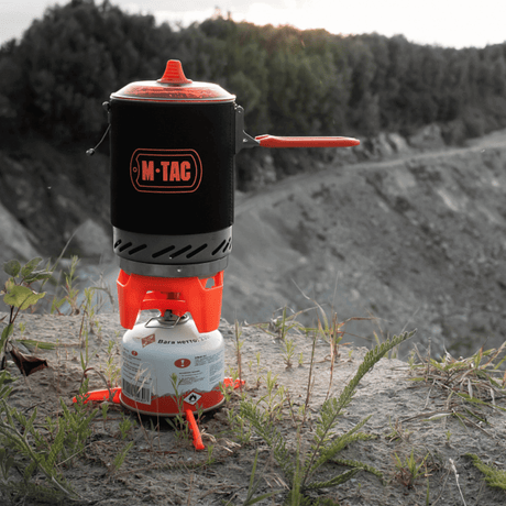 M-Tac Gasbrænder med Kedel i brug på klippe, ideel til camping og vandreture, kompakt og energieffektiv madlavningssystem.