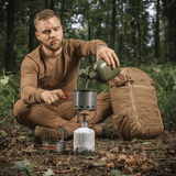 Mand bruger M-Tac Individuelt Kogesæt til Brænder under udendørs camping i skov