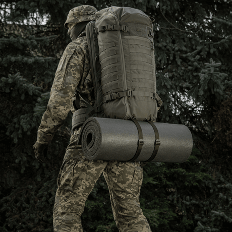 Soldat med rygsæk og M-Tac Liggeunderlag 20 mm (60x180 cm) i naturen til friluftsliv og ekstremt klima.