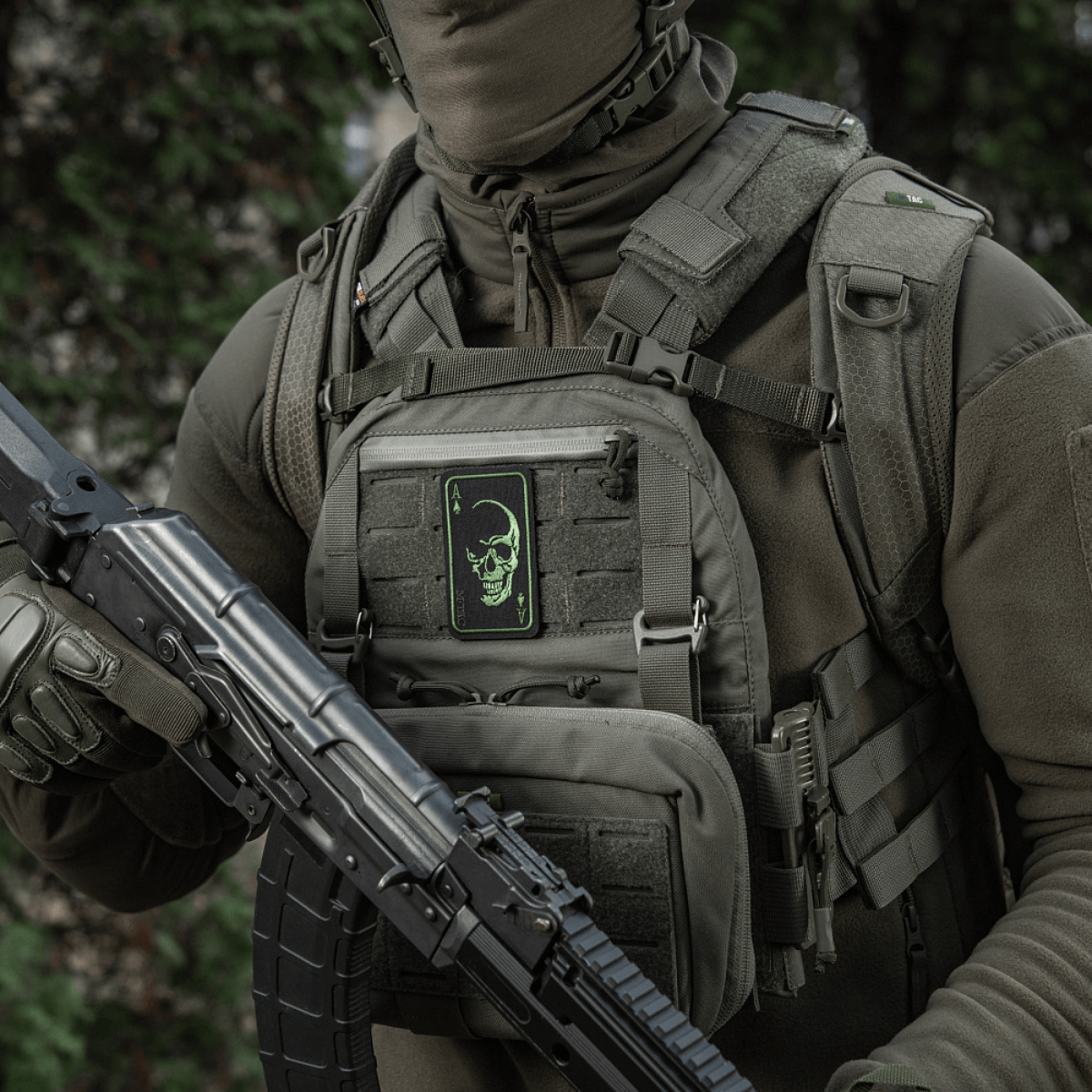 Person med M-Tac Patch Face of War (Broderi) på vest, broderet kranium, inspireret af Vietnamkort, fastgjort med Velcro, taktisk udstyr.