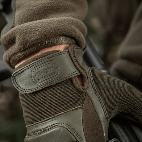 M-Tac Handsker Assault Tactical Mk.2 i brug med justerbar velcro for sikker pasform og syntetisk indsats for forbedret greb.